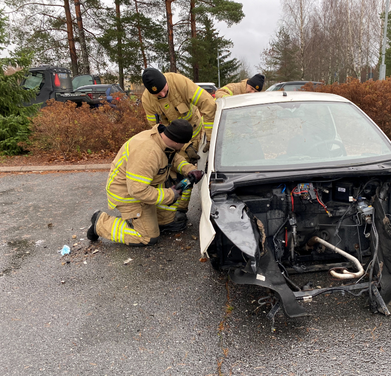 Palomiehet Juhani Lääti, Tommi Toivonen sekä Jani Lehtinen sahaamassa mopoauton tukipilaria. Kuvat: Pihla Torvinen