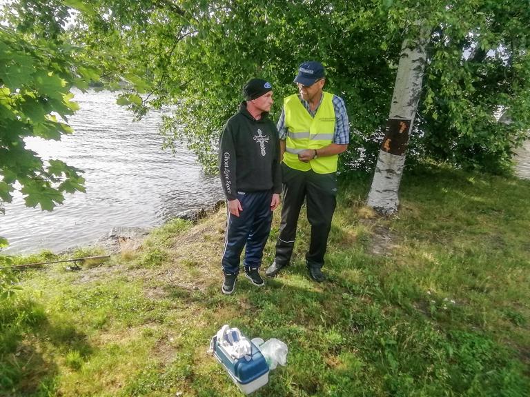 Kaikki kunnossa! Valvoja Esko Piranen tarkastamassa kalastajan lupia Liekoveden rannalla.