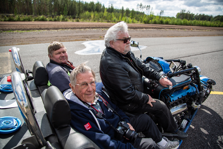 Leevi Laitinen ja Markku Arola pääsivät Kari Isotalon custom-valmisteisen triken kyytiin Tuulikki-Vampulan lentokentällä. Kaikkia tehoja pyörästä ei sentään otettu irti, vaikka kiitorataa olisikin riittänyt, vaan miehet rullailivat kaikessa rauhassa.