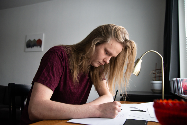 Lauri Nieminen kirjoittaa käsin ja päiväkirjoihin. Kuvat: Mikko Perttunen